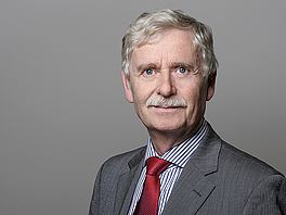 Porträt-Foto von Rainer Borgmann-Quade. Er trägt einen Anzug und schaut freundlich in die Kamera
