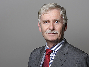 Porträt-Foto von Rainer Borgmann-Quade. Er trägt einen Anzug und schaut freundlich in die Kamera