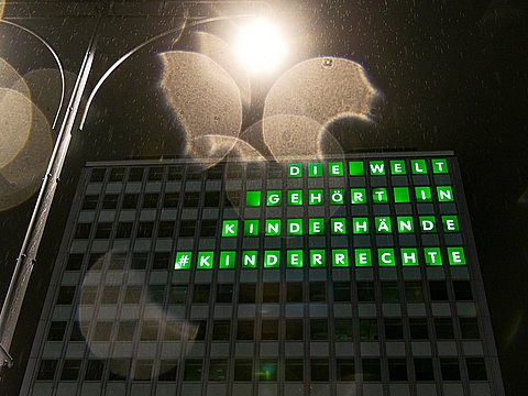 Das Haus des Lehrers mit leuchtendem Schriftzug: "Die Welt gehört in Kinderhände!"