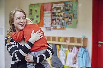 Kind tröstet Erzieherin – in Corona-Zeiten geht das natürlich nur mit Abstand (© FRÖBEL e.V./Boris Breuer)