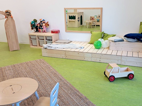 Foto vom Innenbereich des FRÖBEL-Kindergartens Heinrich der Löwe in Braunschweig. Holzpodest mit Spielzeug
