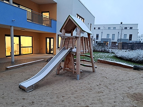 Foto vom Außenbereich des FRÖBEL-Kindergartens Heinrich der Löwe in Braunschweig mit Kletterturm und Rutsche