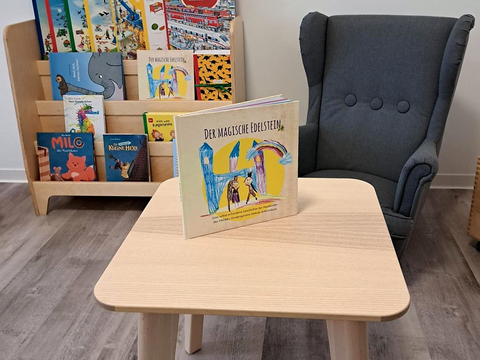 Foto vom Innenbereich des FRÖBEL-Kindergartens Heinrich der Löwe in Braunschweig. Leseecke mit großem Sessel und Büchern im regal.