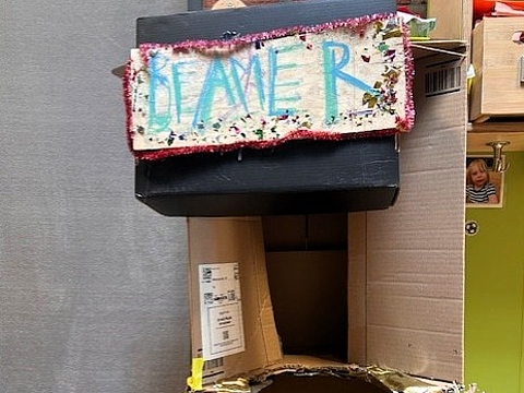 Installation aus Karton mit einem aufgesetzten Projektor, davor strukturierte Papier- und Kartonelemente.