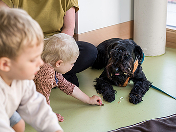 Kita-Kinder mit Hund im Fröbel-Kindergarten Sigmaringer Straße in Stuttgart (© FRÖBEL e.V./Foto: Yannick Wegner)