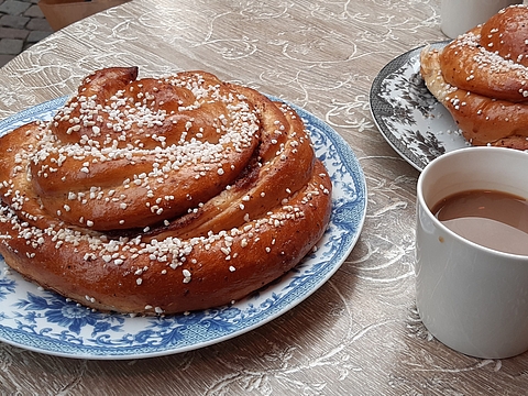 Foto von einem gedeckten Tisch mit Kaffee und schwedischen Kanelbullar (Zimtschnecken)