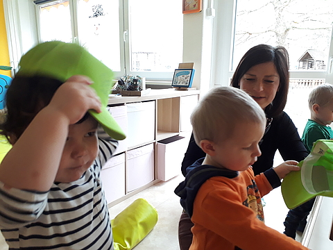 Erzieherin Anja Schneider im Gespräch mit zwei größeren Kindern der Krippengruppe.